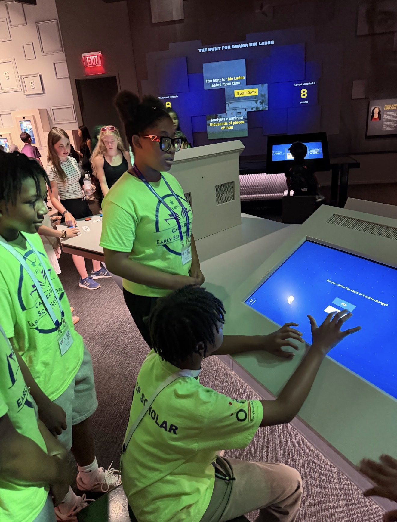 Scholars exploring an interactive exhibit at the Spy Museum